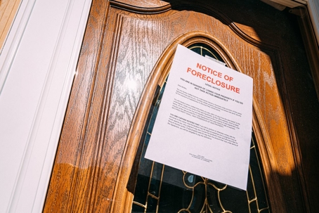 Notice of Foreclosure letter taped onto the front door of a house